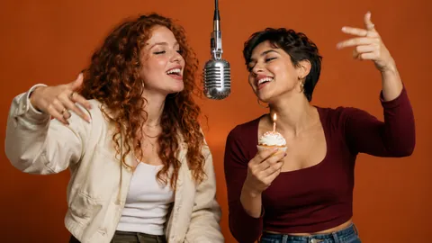 Two fictional adult friends celebrating at the orange-stage microphone